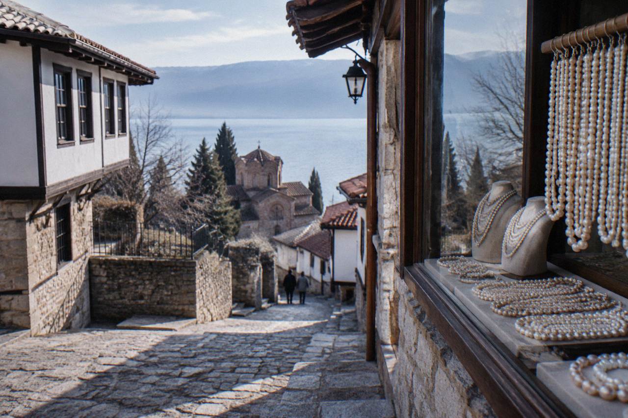 A jewellery shop display of strands of pale Ohrid pearls beside a lakefront street in Ohrid