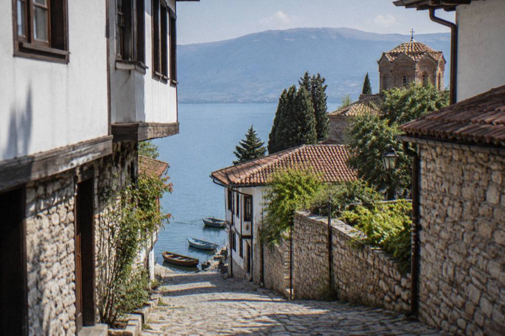 Wooden boats moored on the shore of Lake Ohrid below the old town