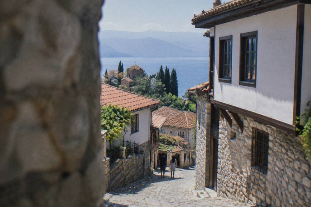 A mountain road winding through green hills above Lake Ohrid