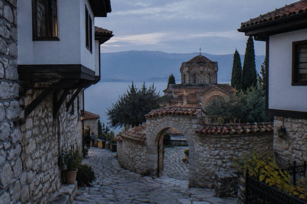 Walled church courtyard with stone arches in Ohrid old town