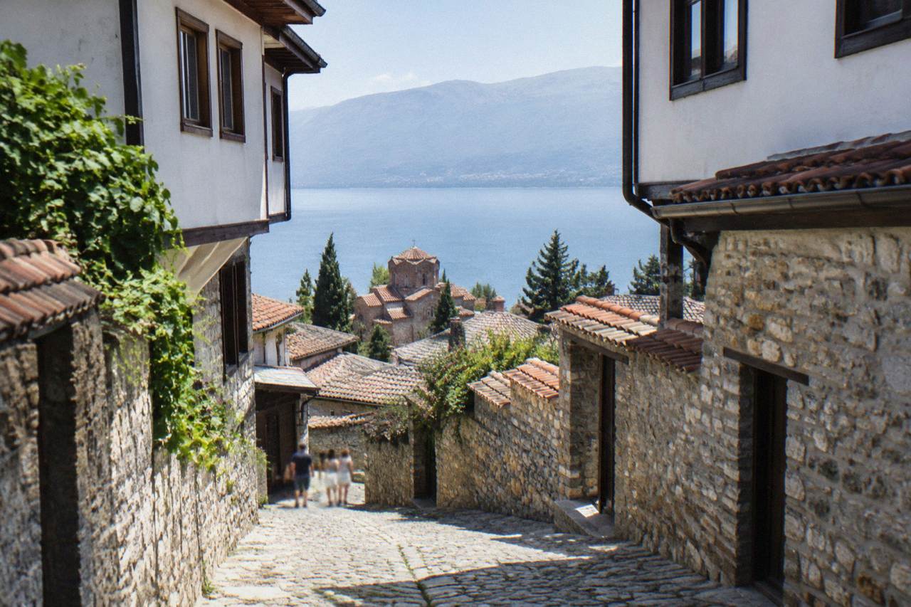 Stone lanes and red-tiled roofs of Ohrid old town rising above Lake Ohrid