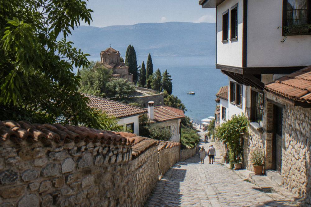 Swimmers and small boats along Lake Ohrid's shoreline on a clear summer afternoon