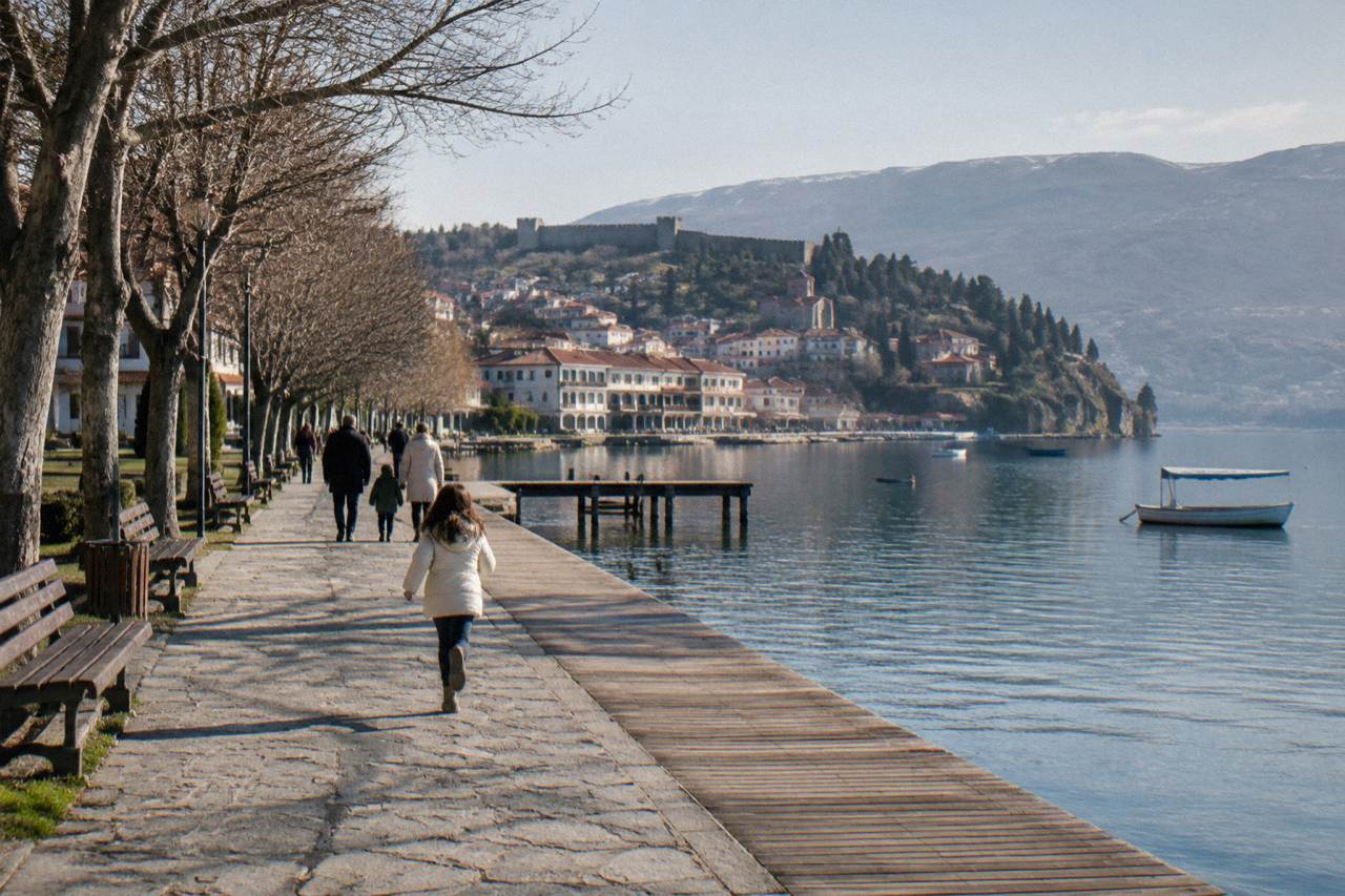 Families walking along the lakeside promenade in Ohrid with boats on the water