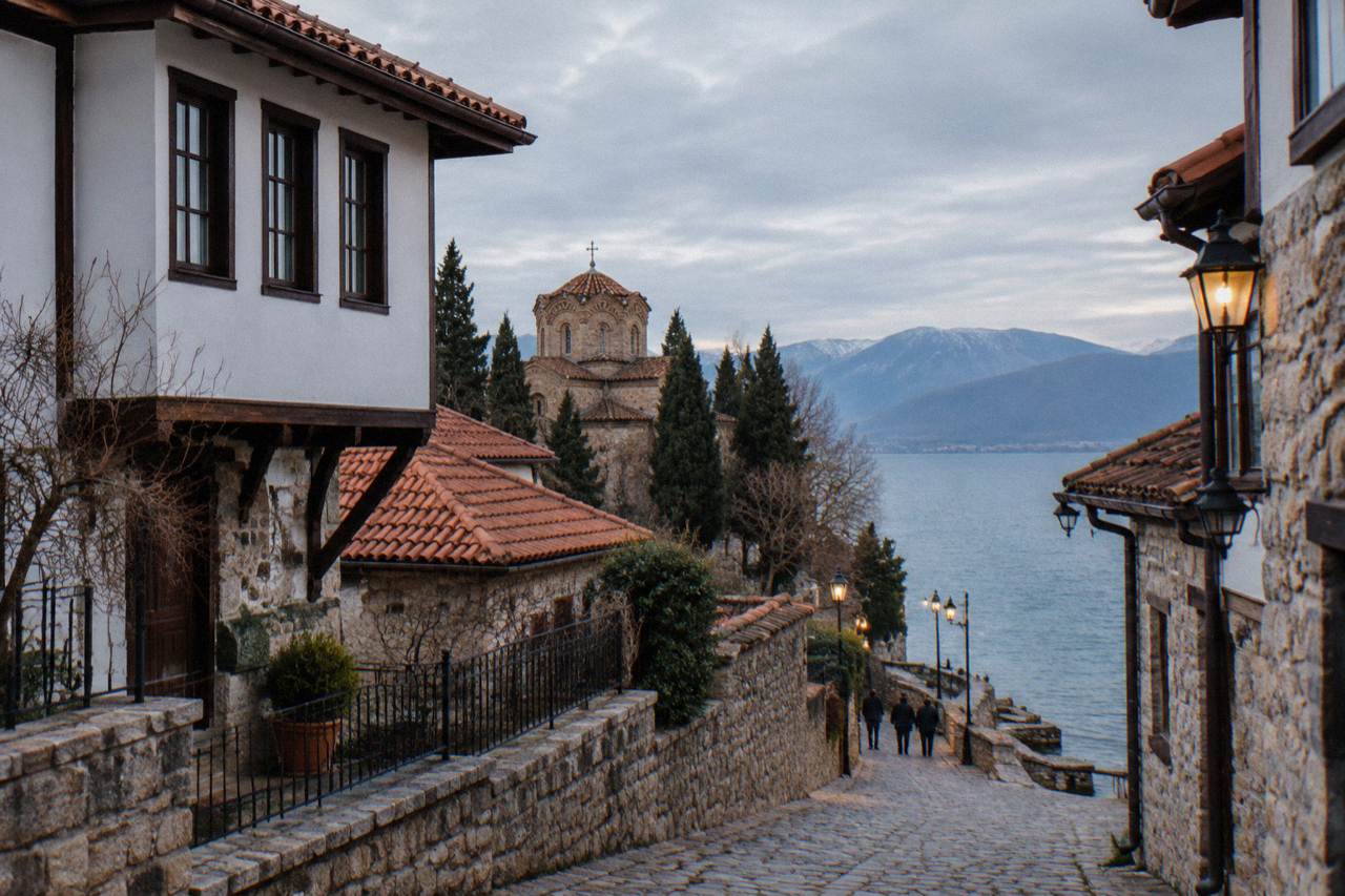 Lanterns glowing along the stone quay of Ohrid with the dark water of Lake Ohrid behind