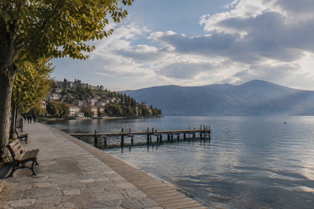 A wooden jetty and calm lake water near Ohrid's shoreline in evening light