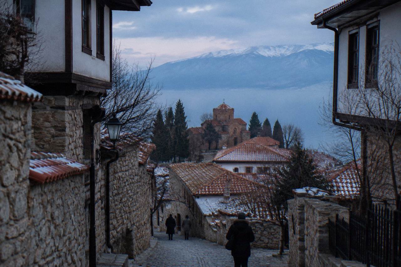 Ohrid old town rooftops and church domes above the shore of Lake Ohrid under a pale winter sky