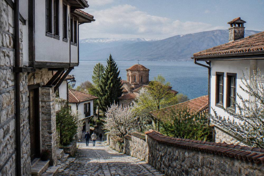 Clear spring water channels beside a monastery on Lake Ohrid seen from a small rowboat
