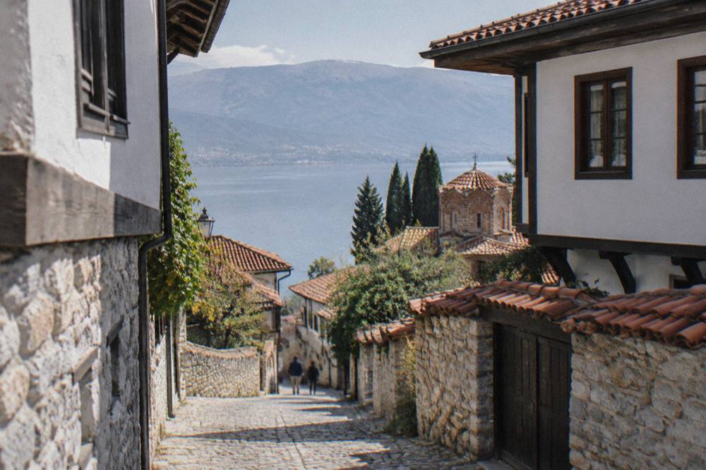A small lakeside town at the north end of Lake Ohrid seen across calm water