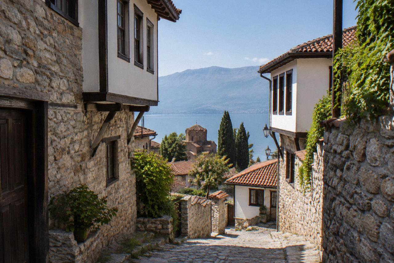 Old stone houses of Ohrid rising above the shoreline of Lake Ohrid under a clear sky