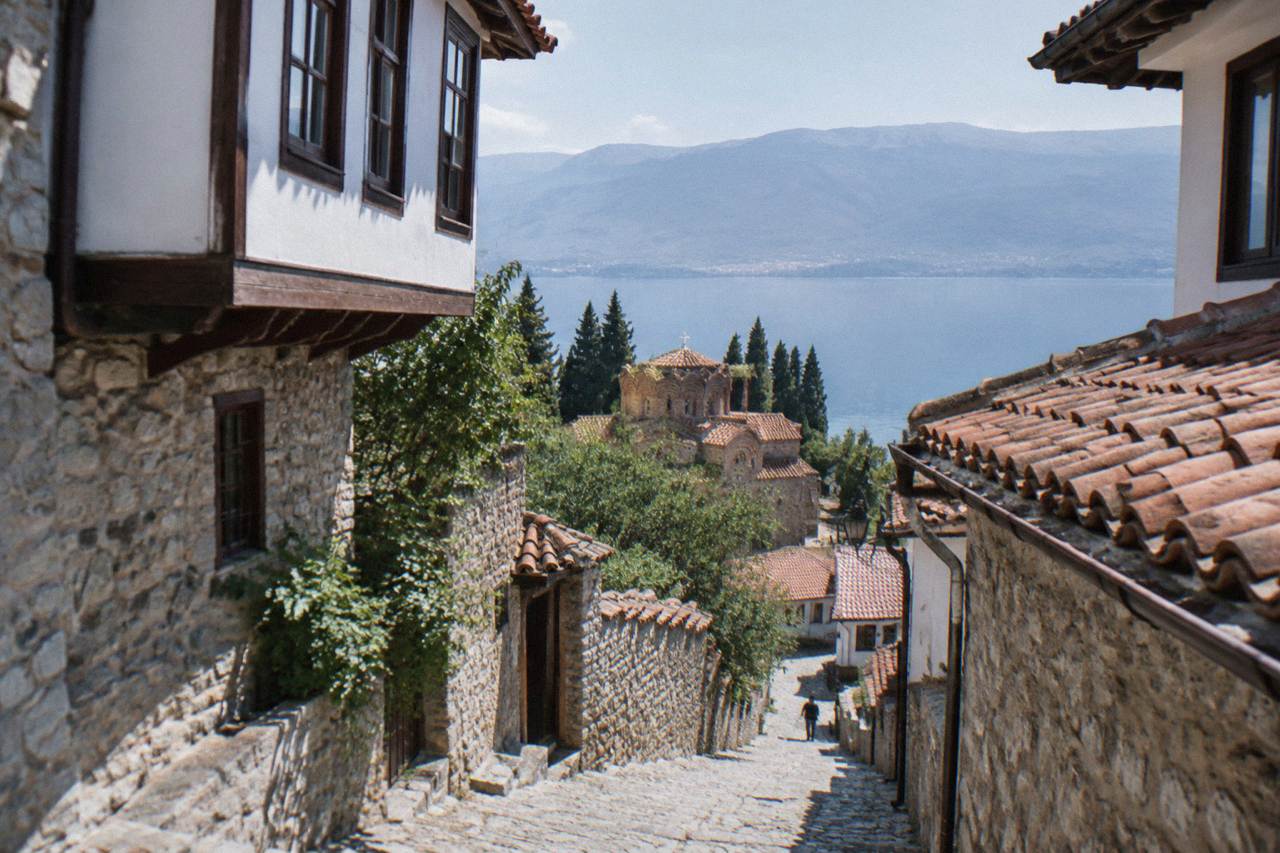 Clear green water of Lake Ohrid along the shoreline near Ohrid with hills rising behind