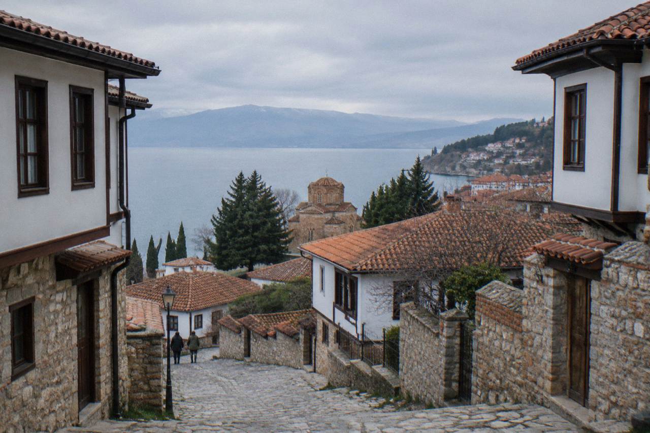 Ohrid old town rooftops rising from the shore of Lake Ohrid toward green hills