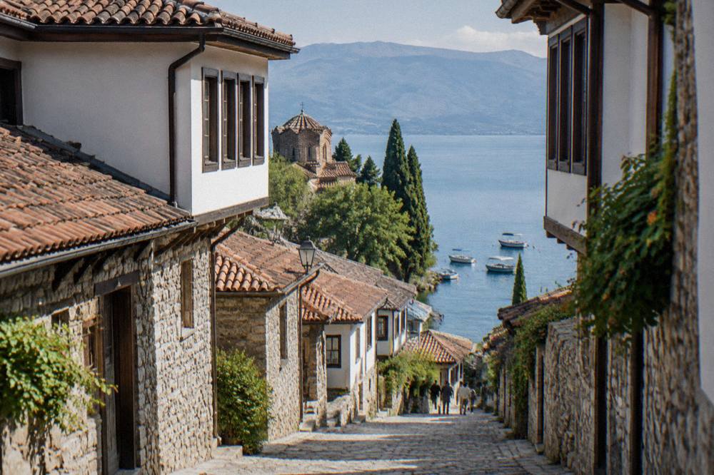 Boats moored on clear water along the Lake Ohrid shoreline near Ohrid