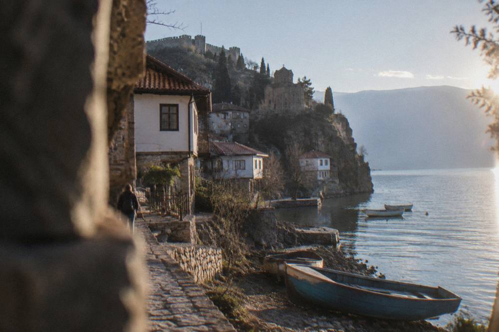 Boats moored on Lake Ohrid below the cliff of the Kaneo district in Ohrid