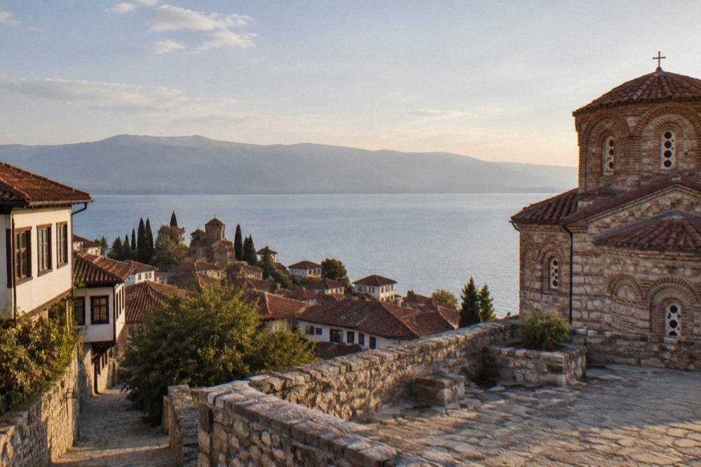 The terrace of a stone church above the rooftops of Ohrid with Lake Ohrid behind