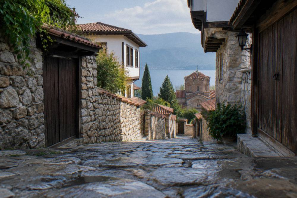 A quiet lane in the Ohrid old town with stone walls and wooden gates
