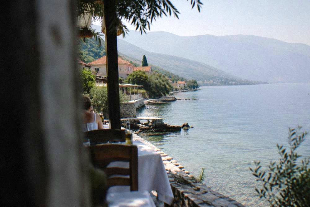 A terrace above the lake with tables set for eating beside the water