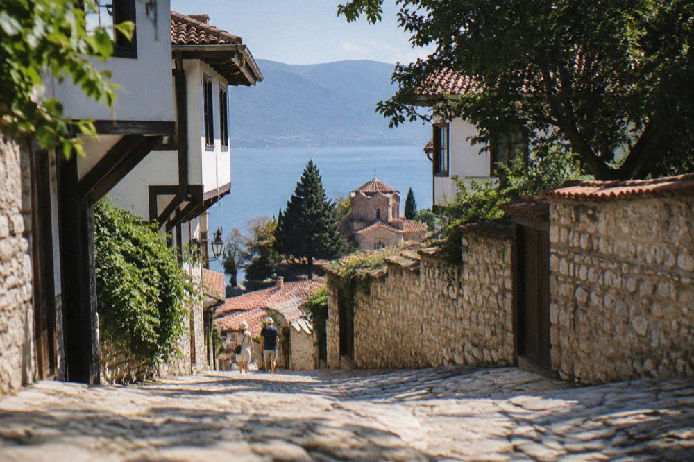 Red-tiled roofs of Ohrid old town sloping down to the blue water of Lake Ohrid under a clear sky