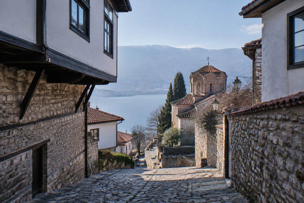 Stone church with a tiled roof standing above the old lanes of Ohrid near the lake