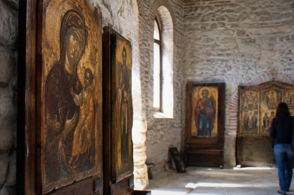 Wooden icon panels and religious paintings displayed in a gallery interior