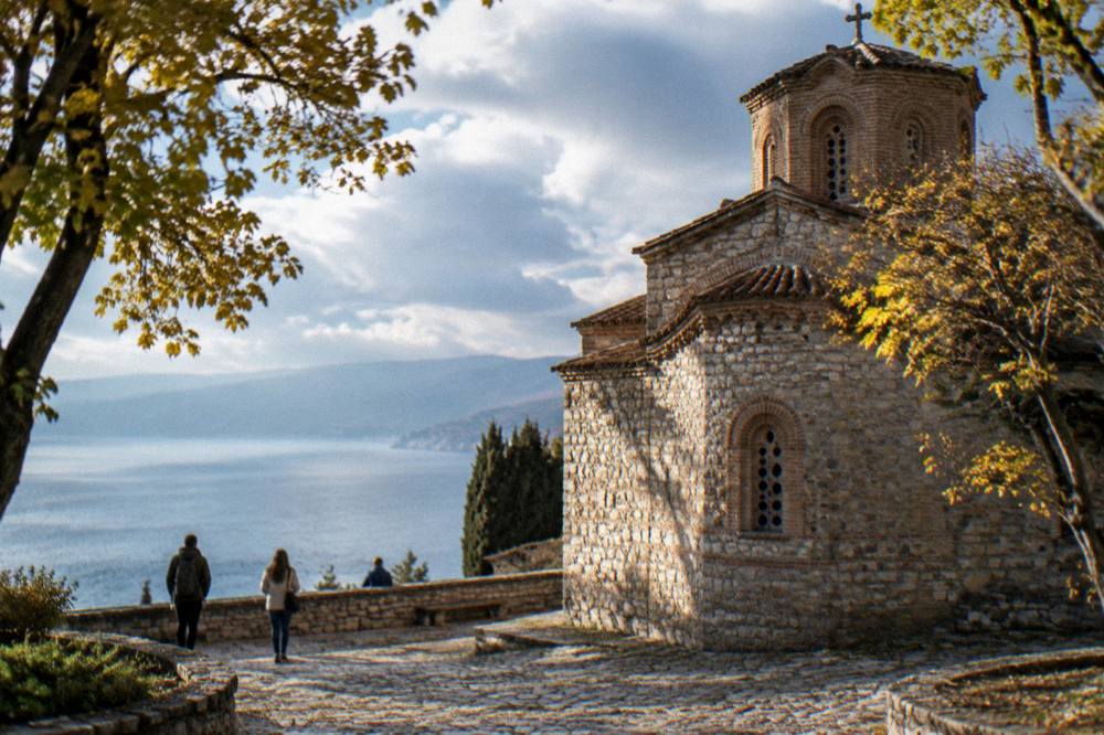 Sunlight falling on a stone church wall and courtyard in an old lakeside town