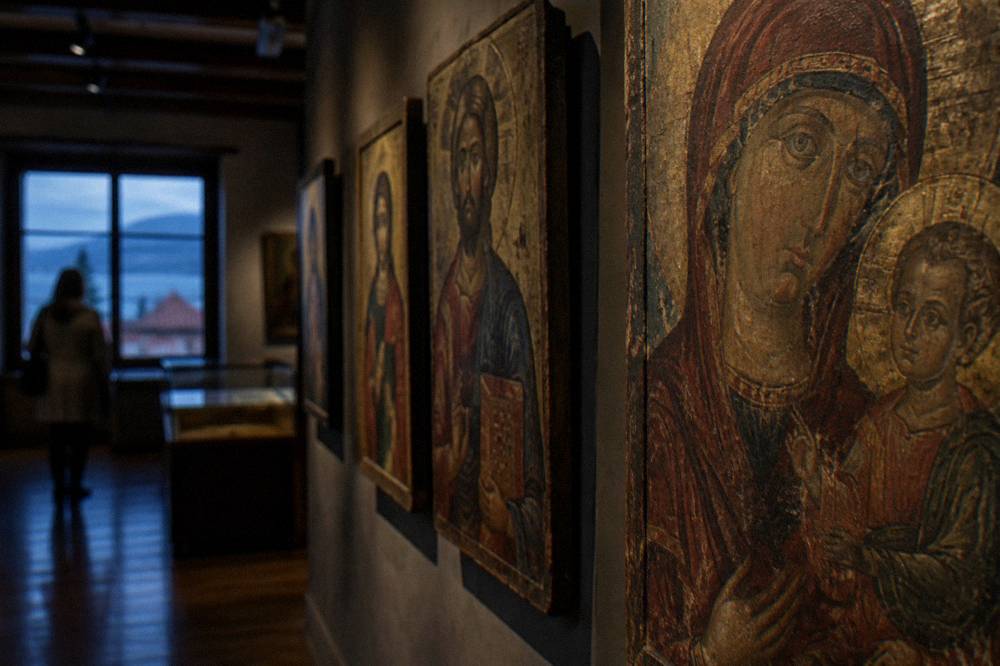 Painted wooden icons displayed in a dim gallery room