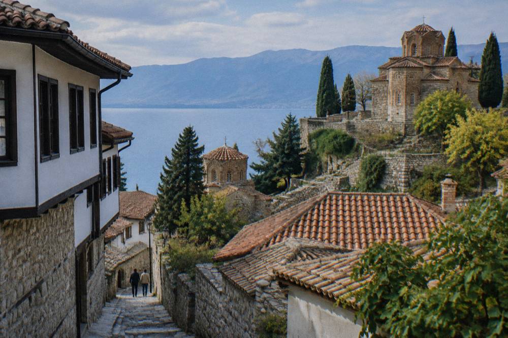 A stone church complex on a terraced slope above the rooftops of Ohrid