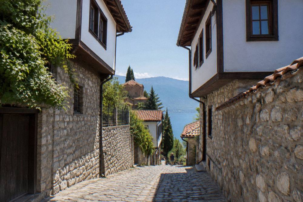 A narrow stone lane in Ohrid's old town climbing between traditional houses