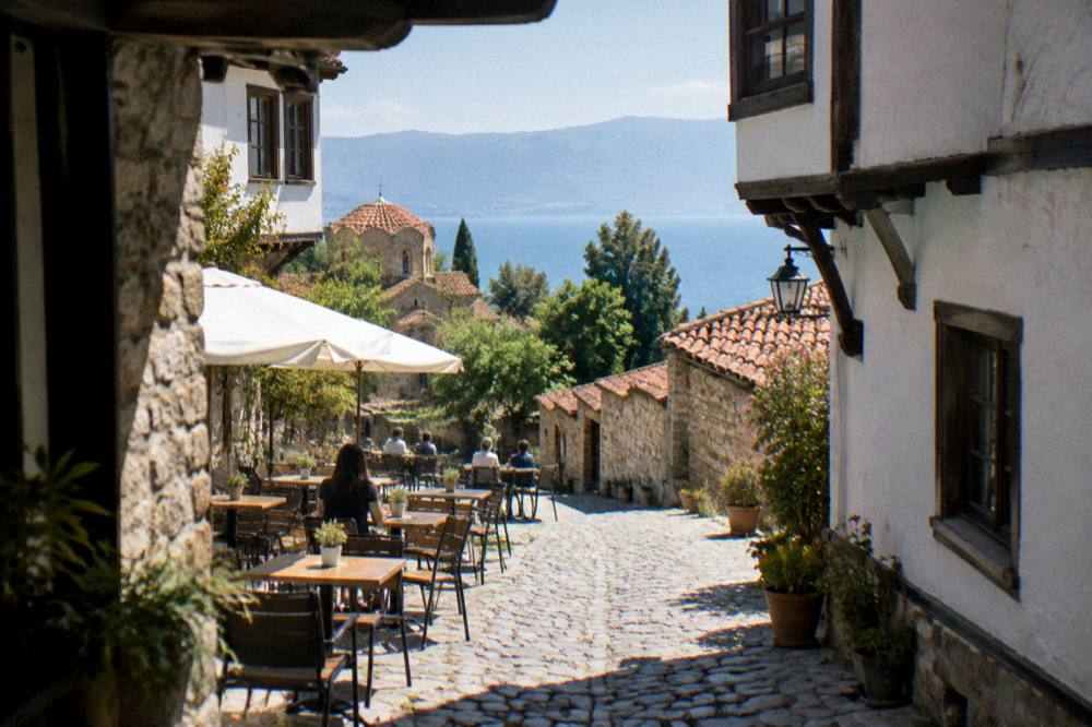 A cafe terrace with small tables on a cobbled Ohrid lane