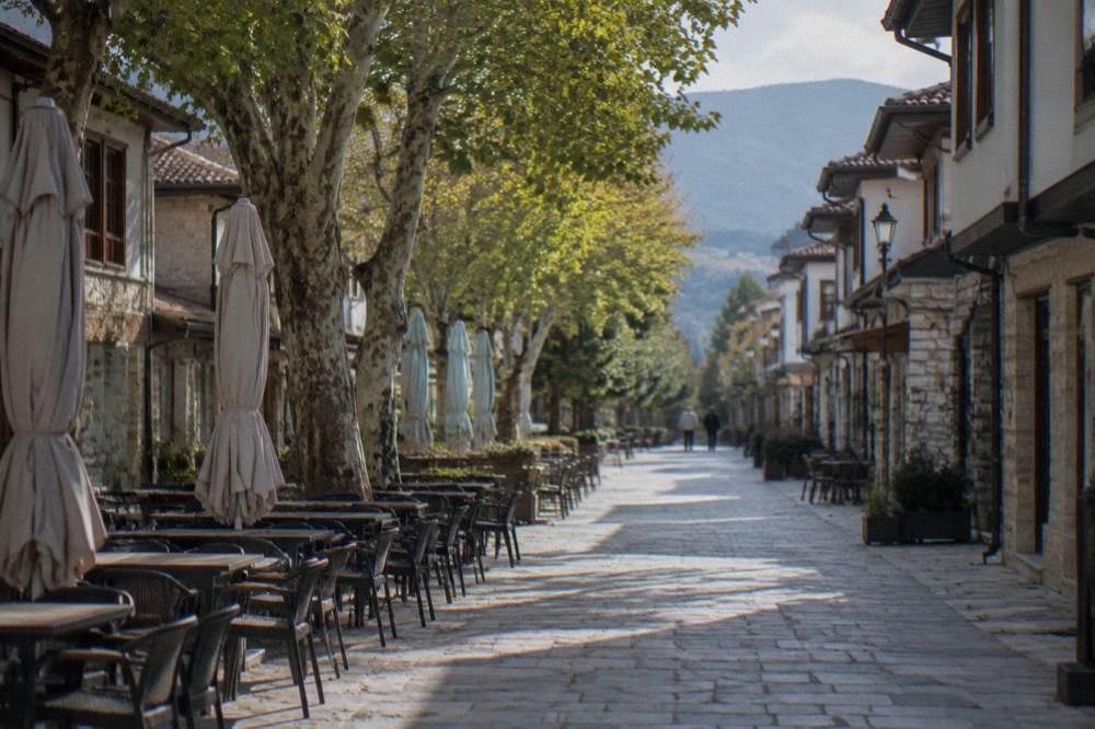 An empty pedestrian street in Bitola with cafe tables and plane trees in the morning