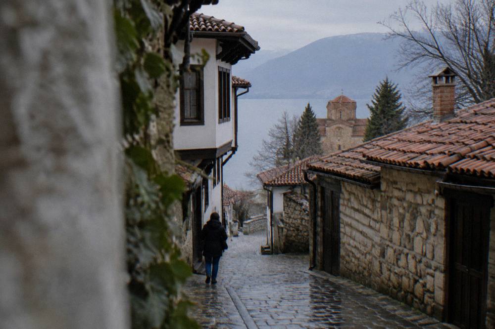 A quiet border-area road between Lake Ohrid and green hills near the Albanian frontier