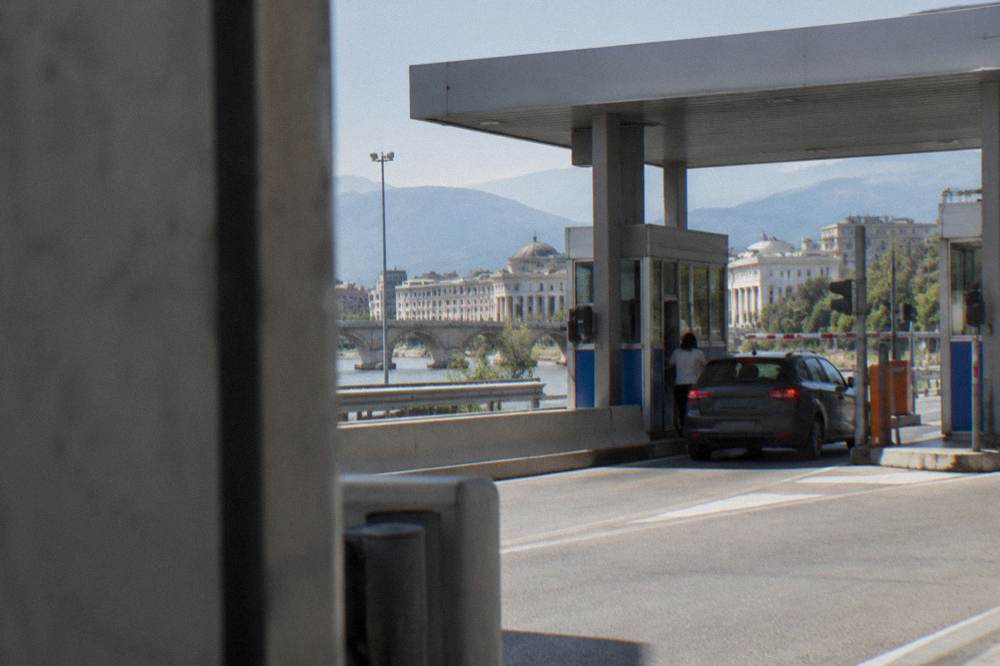 A motorway toll plaza with a car paying at a booth in North Macedonia