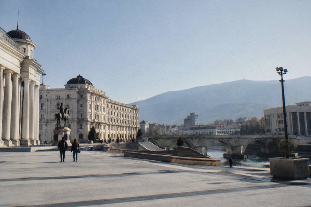 An Albanian border checkpoint building beside a road with hills behind