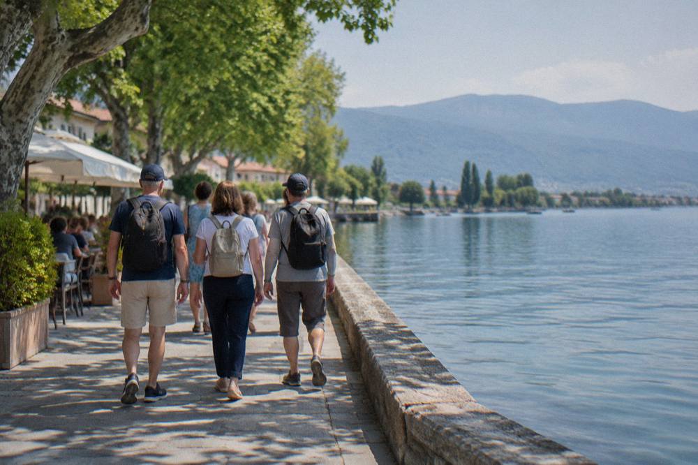 A small tour group walking together along the river bank in Struga