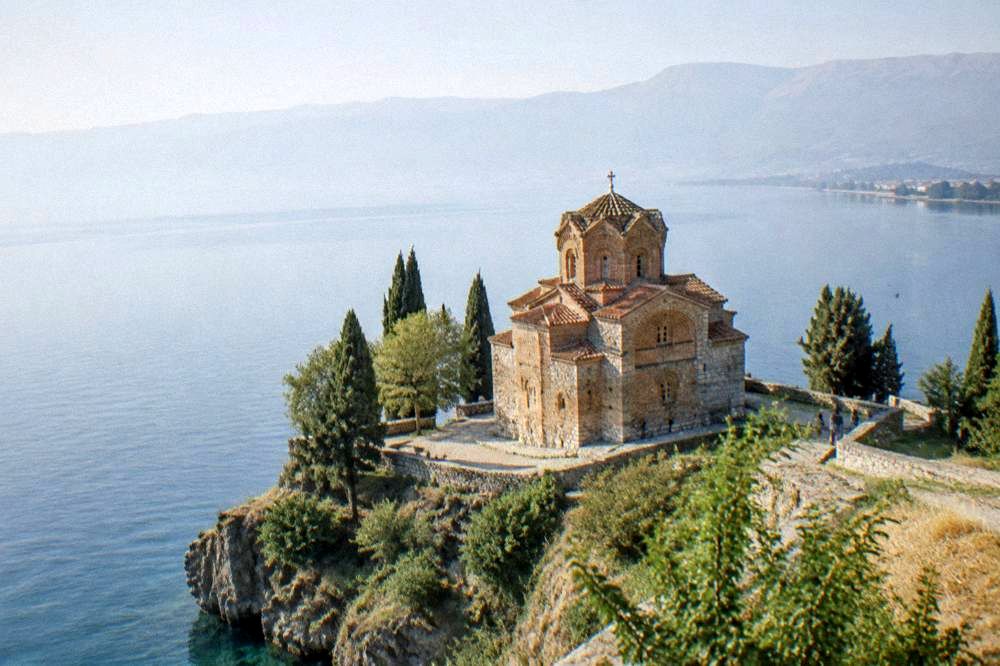 A calm morning on Lake Ohrid with the church of St John at Kaneo on the headland