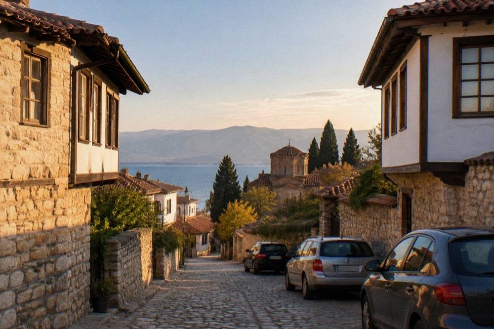 A narrow old-town street in Ohrid with parked cars and stone houses