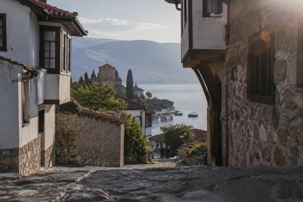 Boats moored on Lake Ohrid with the old town waterfront behind them