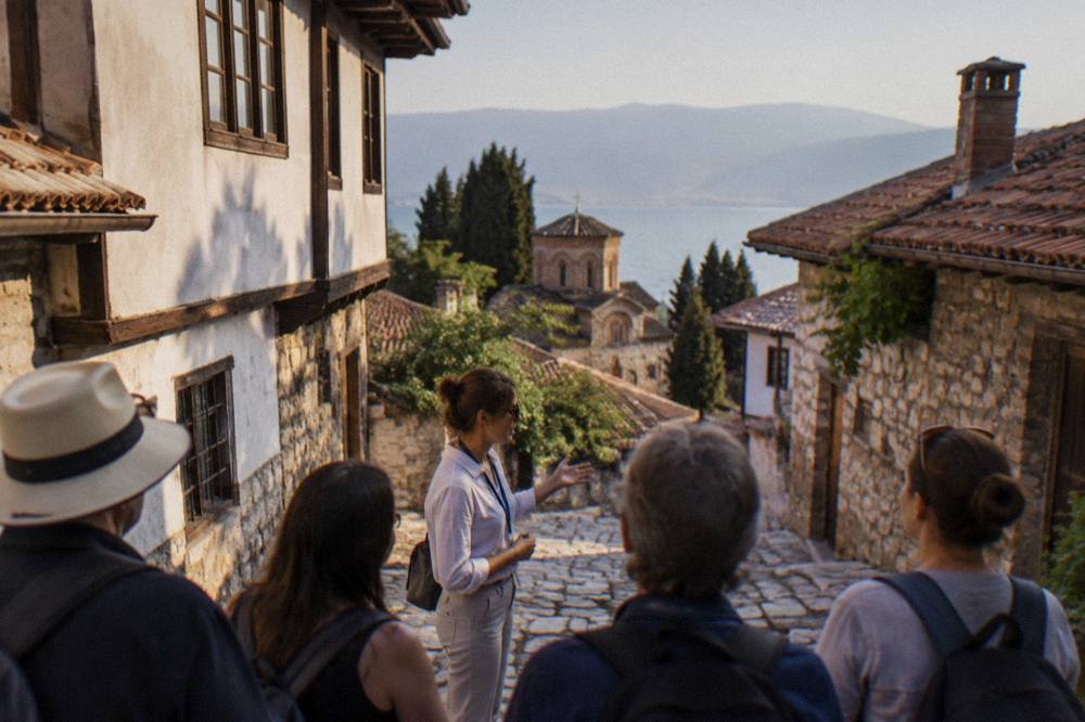 A guide speaking to a small group of visitors on a stone street in Ohrid