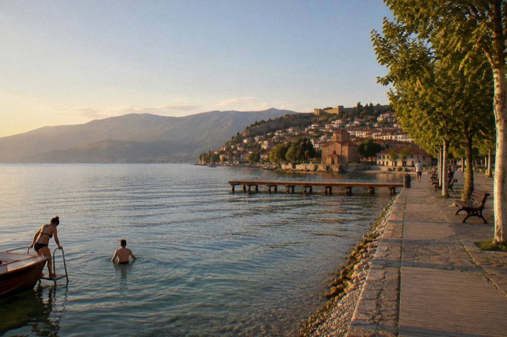 Swimmers stepping from a boat ladder into clear green water near a pebble shore