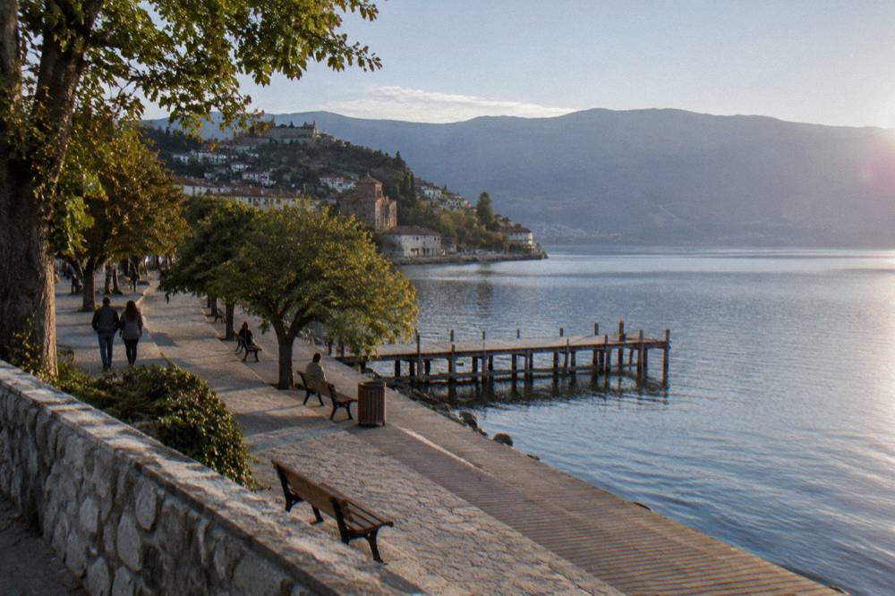 A reconstructed prehistoric wooden settlement built on stilts over a lake shore