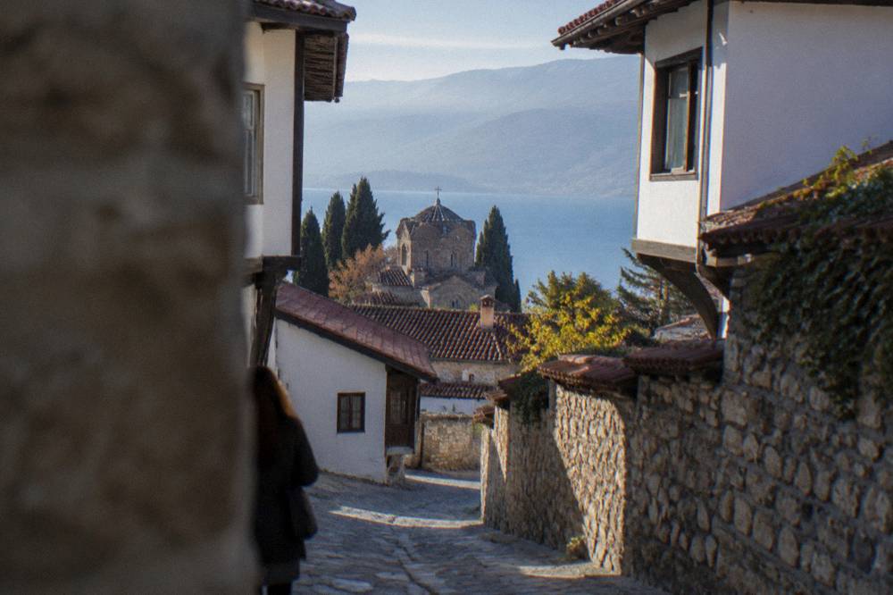 A narrow stone lane in the Ohrid old town with whitewashed houses and a stone wall
