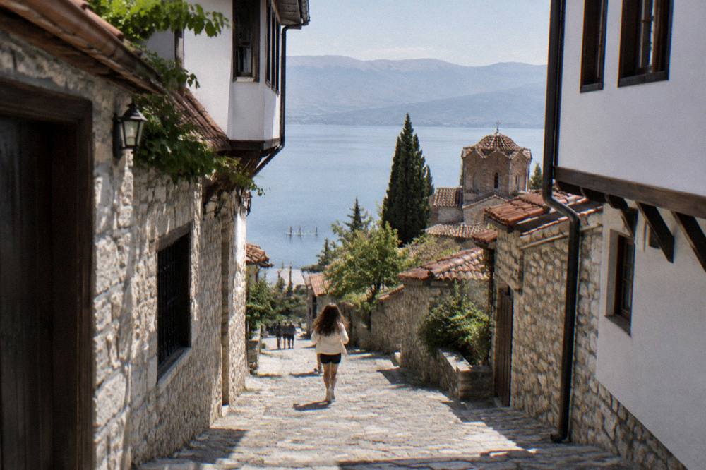 Paddleboards floating on still water near the Ohrid shore with hills in the background