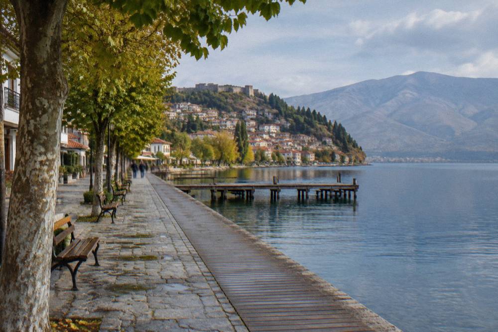 A flat lakeside boardwalk in Ohrid with the water on one side and low buildings on the other