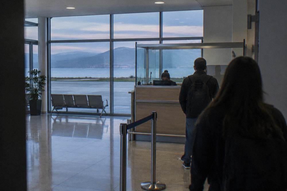 A passport control desk in a small bright airport arrivals hall