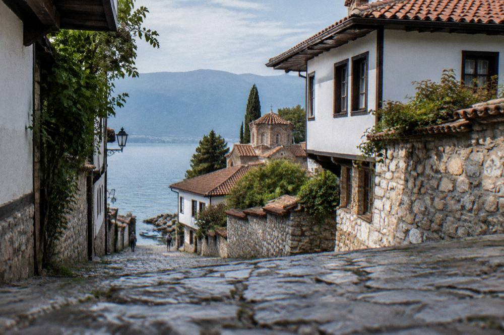 Paddleboards floating on still water beside a rocky shoreline on Lake Ohrid