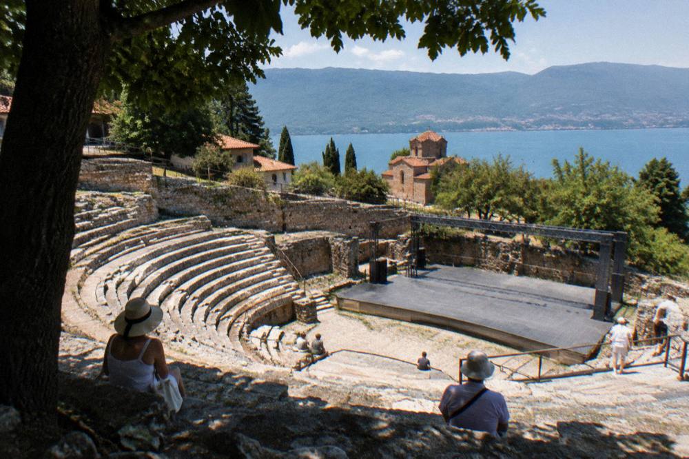 Stone rows of an ancient open air theatre with a modern stage at the bottom