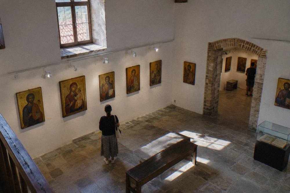 Rows of framed religious icons lit on the white walls of a small museum gallery