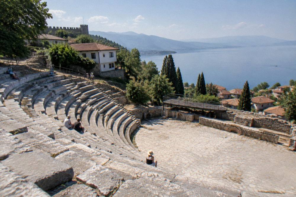 Stone seats of the Ancient Theatre of Ohrid with the lake in the distance