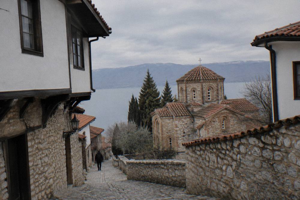 The stone exterior of a Byzantine church in Ohrid seen from a cobbled path