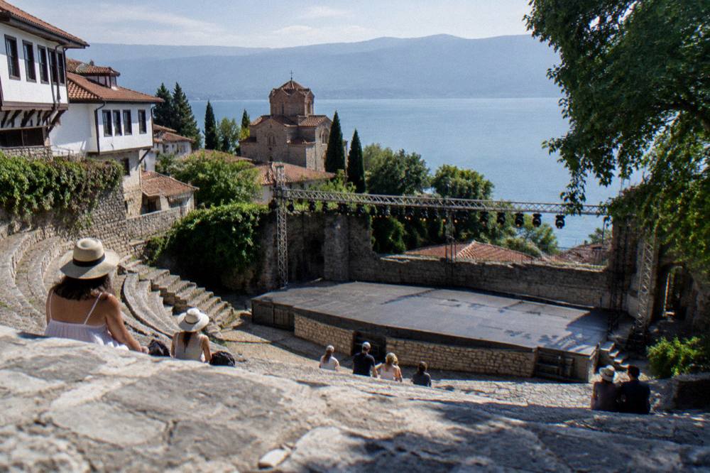 An outdoor stone theatre stage lit for an evening performance in Ohrid