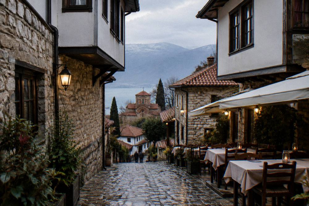A stone lane in Ohrid old town with restaurant tables set out for the evening